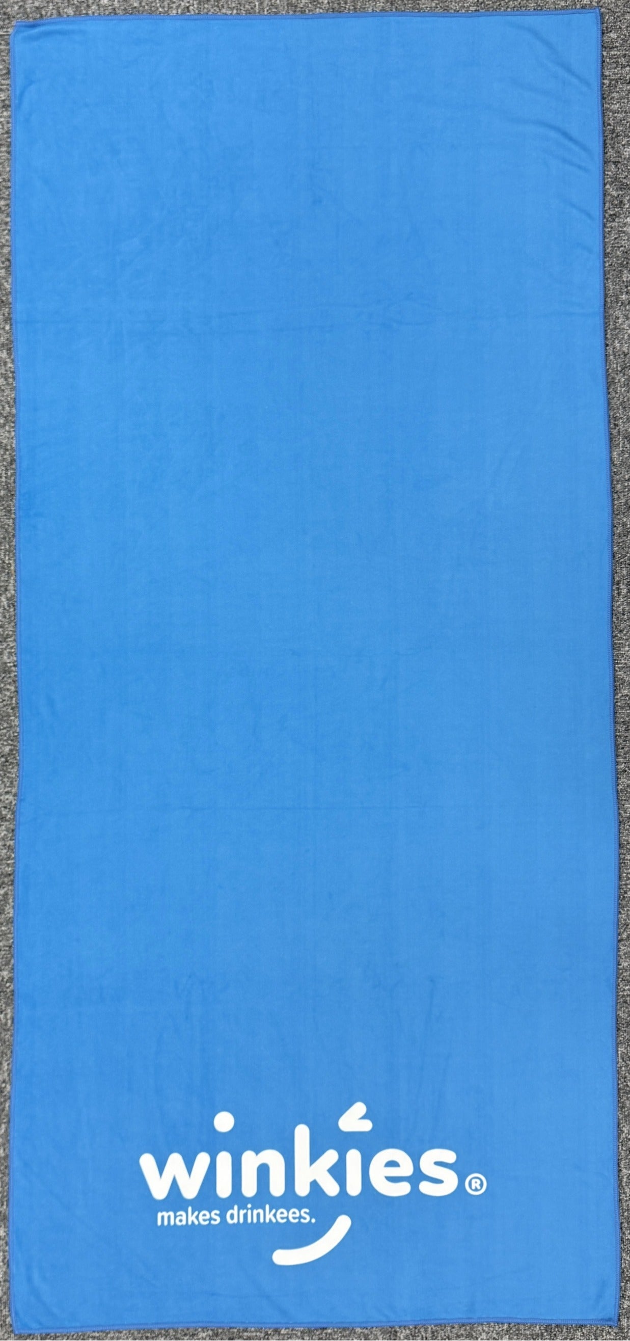 Blue towel with 'winkies' branding on a gray background